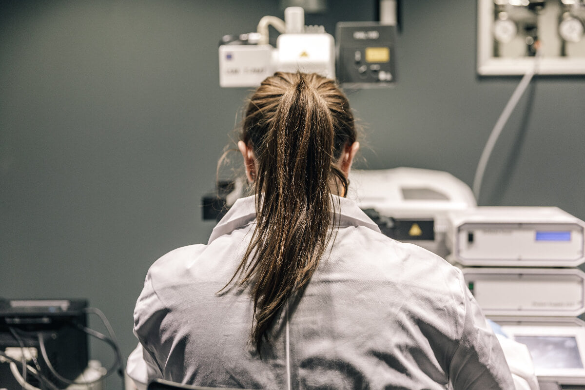 Person in a lab coat working on medical equipment in a laboratory setting